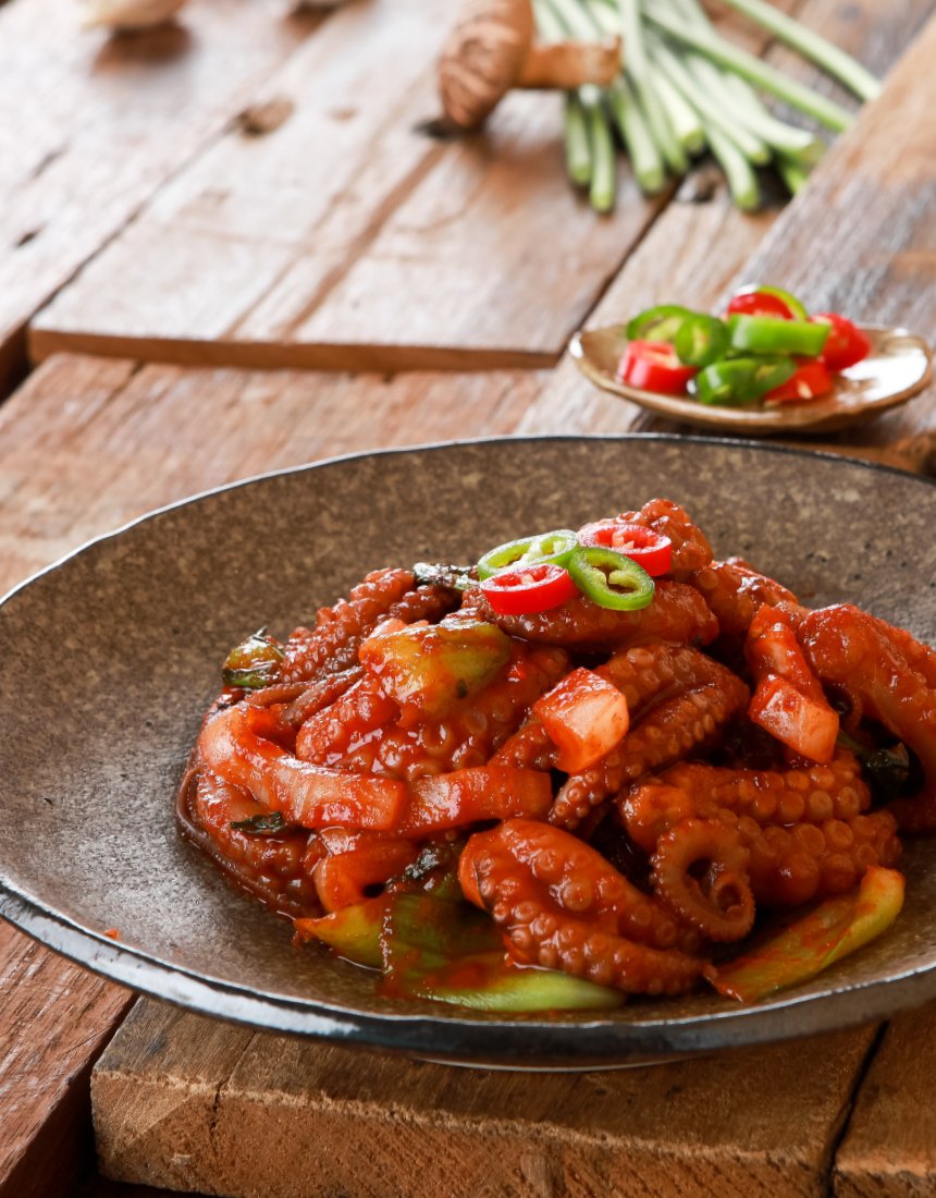 쭈꾸미 무쇠팬 클로즈업 — 고춧가루 양념, 흡반 디테일