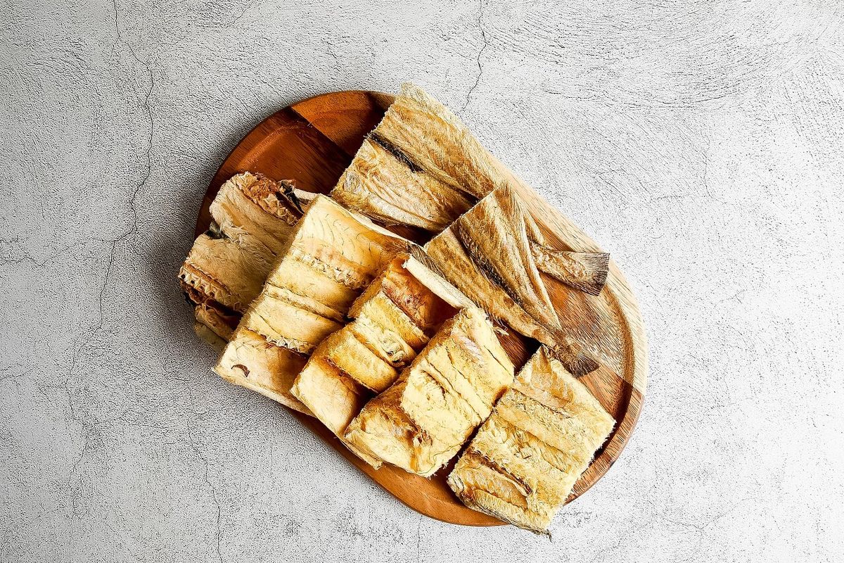 원형 목판 위에 황태채가 가득 담긴 탑뷰, 그레이 배경에서 황금빛 섬유질이 선명하게 보이는 첫 컷