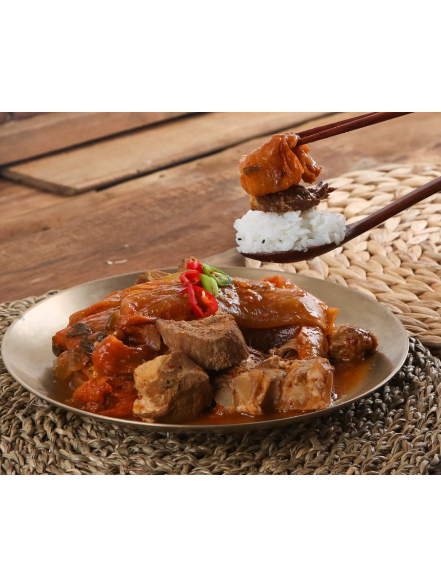 이가장 김치찜 사선 앵글 — 놋접시 위 찜과 고기 질감, 양념 윤기