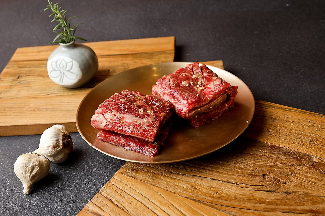 돼지갈비 클로즈업, 놋그릇 위, 마늘과 로즈마리 소품